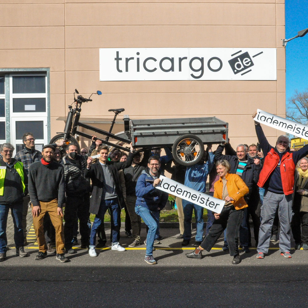 tricargo Genossenschaftsmitglieder vor der Produktionshalle mit Lademeister
